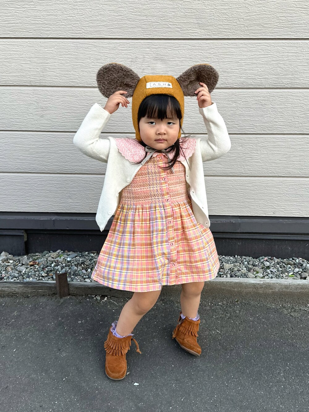 ホワイト系のカーディガン/ボレロ、ピンク系のチュニック、ブラウン系のブーツを着用したキッズの冬コーディネートの4枚目の写真