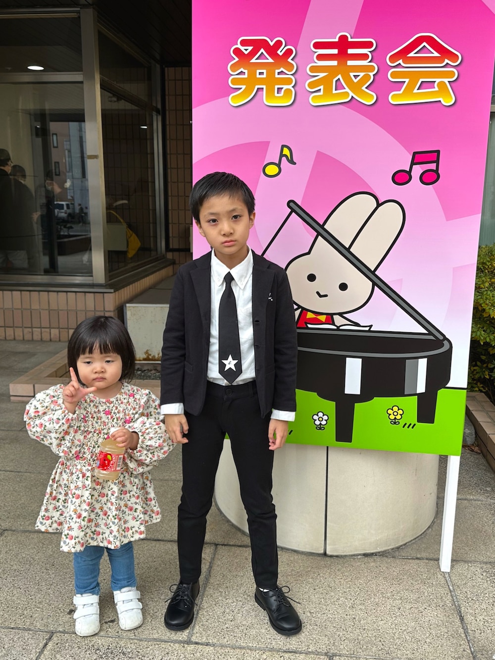 ブラック系のテーラードジャケット、ホワイト系のビジネスシャツ、ブラック系のネクタイを着用したキッズの秋コーディネートの4枚目の写真