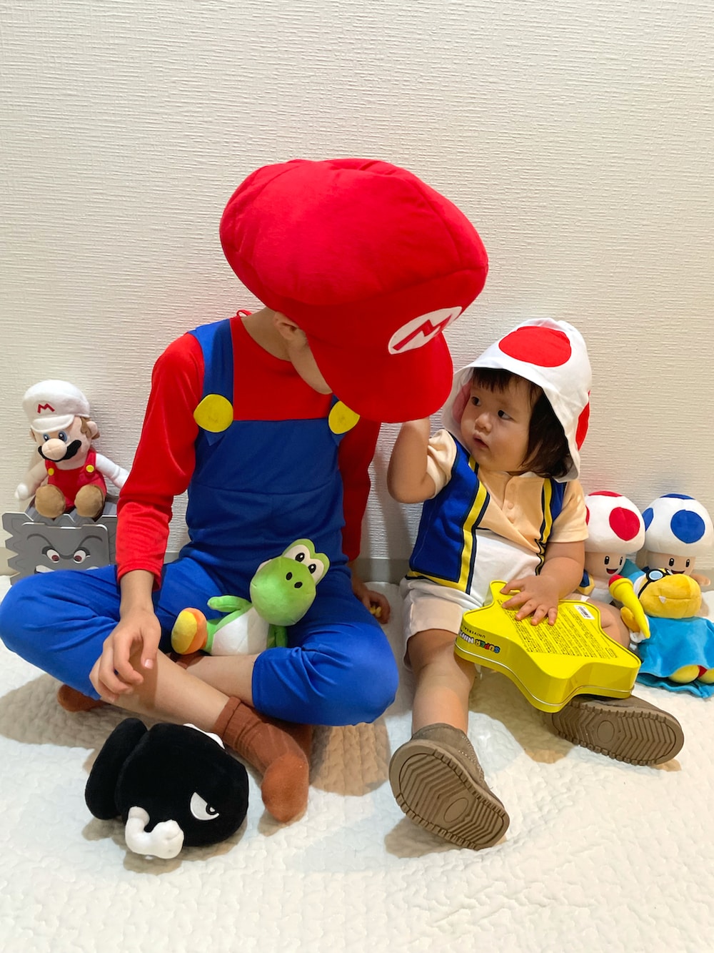レッド系のオールインワン・サロペット、レッド系のキャスケット、ホワイト系のロンパースを着用したキッズの秋コーディネートの5枚目の写真