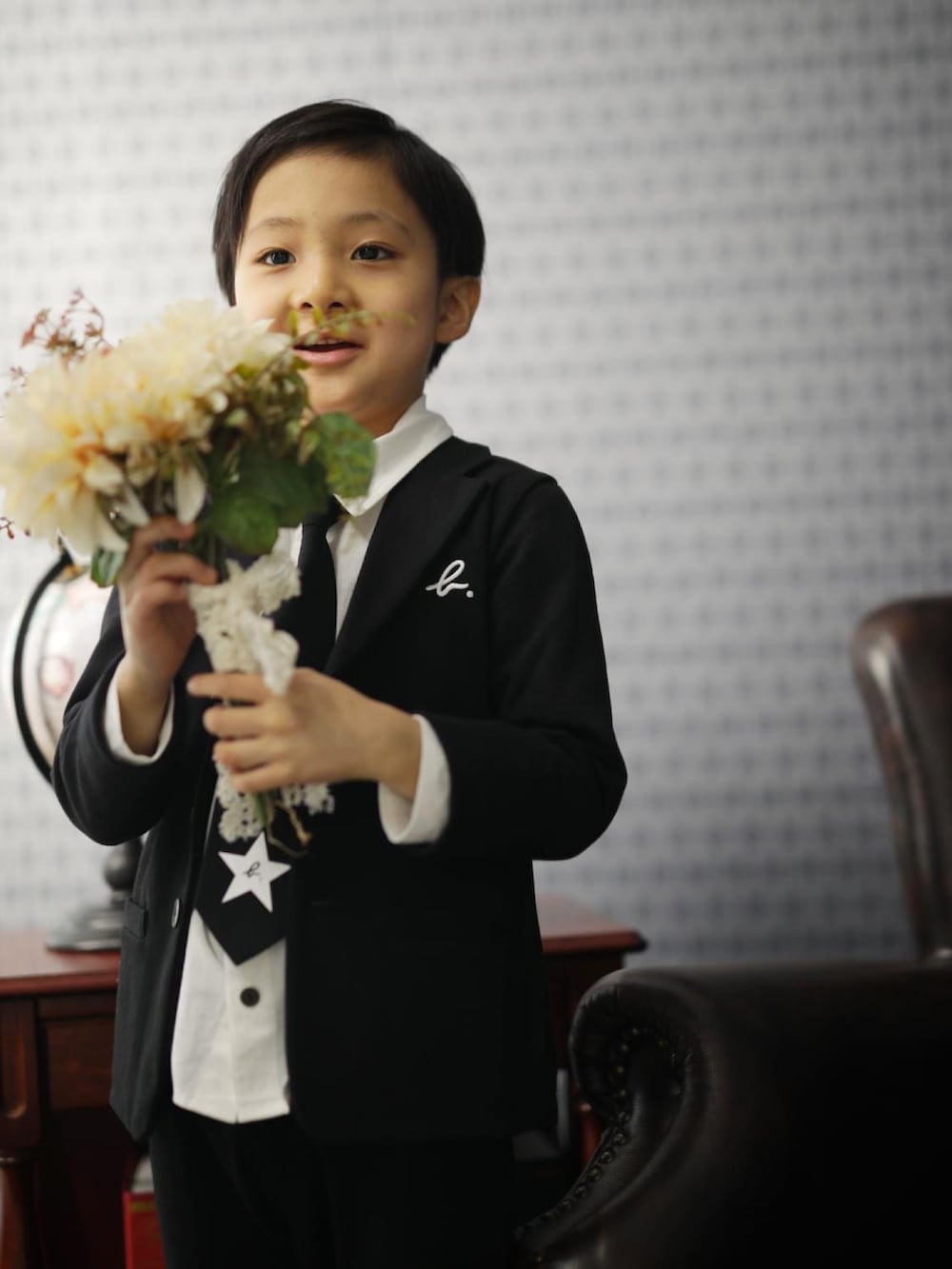 ブラック系のテーラードジャケット、ホワイト系のシャツ/ブラウス、ブラック系のその他パンツを着用したキッズの冬コーディネートの3枚目の写真