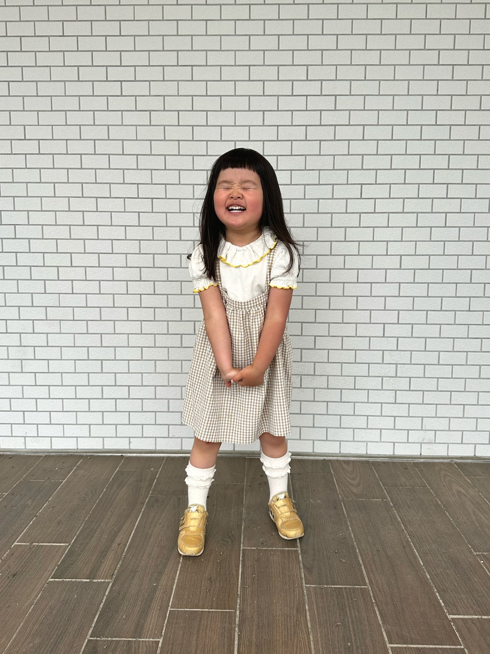 ベージュ系のその他アウター、ゴールド系のスニーカー、ホワイト系のTシャツ/カットソーを着用したキッズの夏コーディネートの2枚目の写真