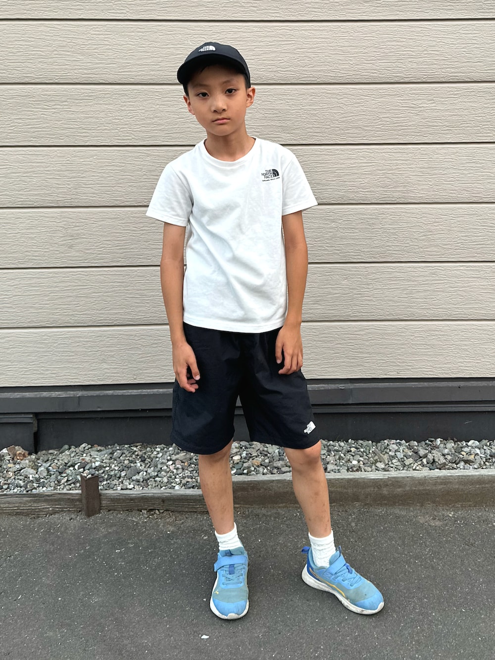 ブラック系のその他パンツ、ブルー系のスニーカー、ホワイト系のTシャツ/カットソーを着用したキッズの秋コーディネートの3枚目の写真