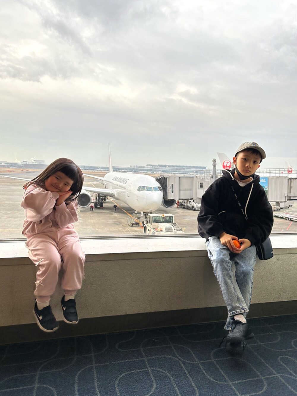 ブラック系のパーカー、その他のデニムパンツ、ブラック系のスニーカーを着用したキッズの春コーディネートの2枚目の写真