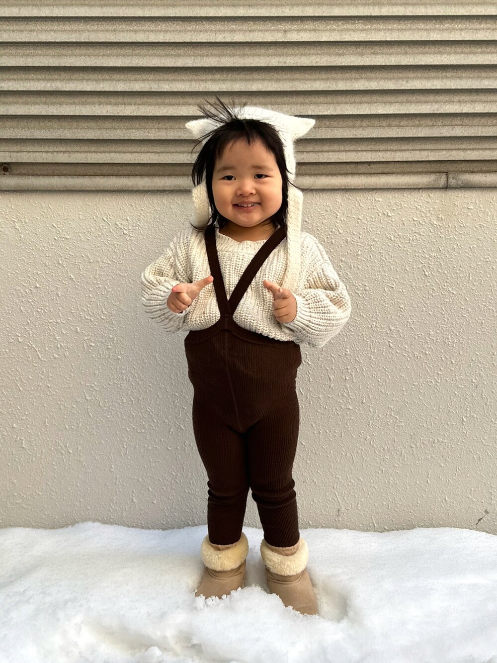 ホワイト系のニット/セーター、ベージュ系のブーツ、ホワイト系のニットキャップ/ビーニーを着用したキッズの冬コーディネートの4枚目の写真