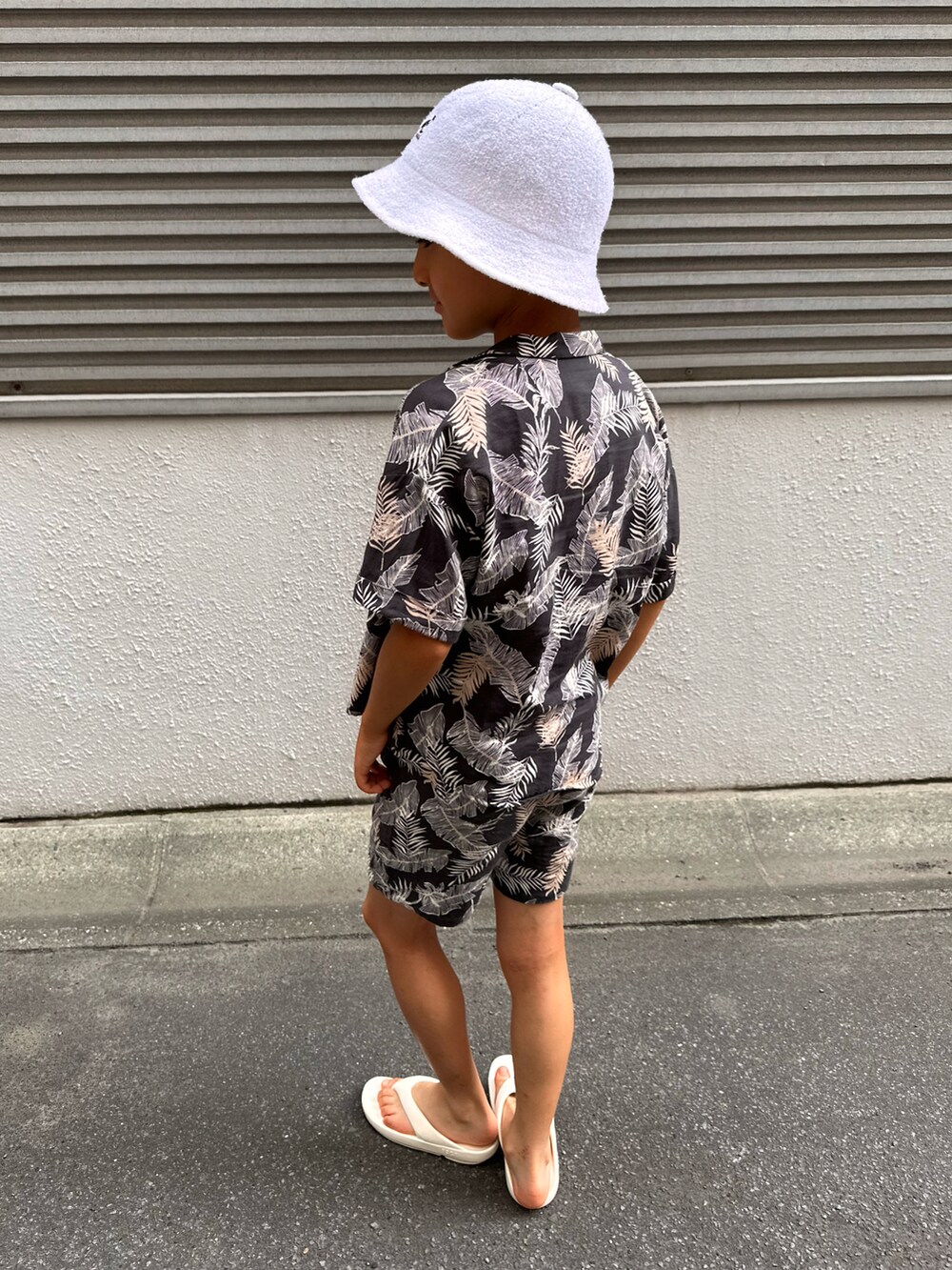 グレー系のシャツ/ブラウス、グレー系のその他パンツ、ホワイト系のサンダルを着用したキッズの夏コーディネートの2枚目の写真