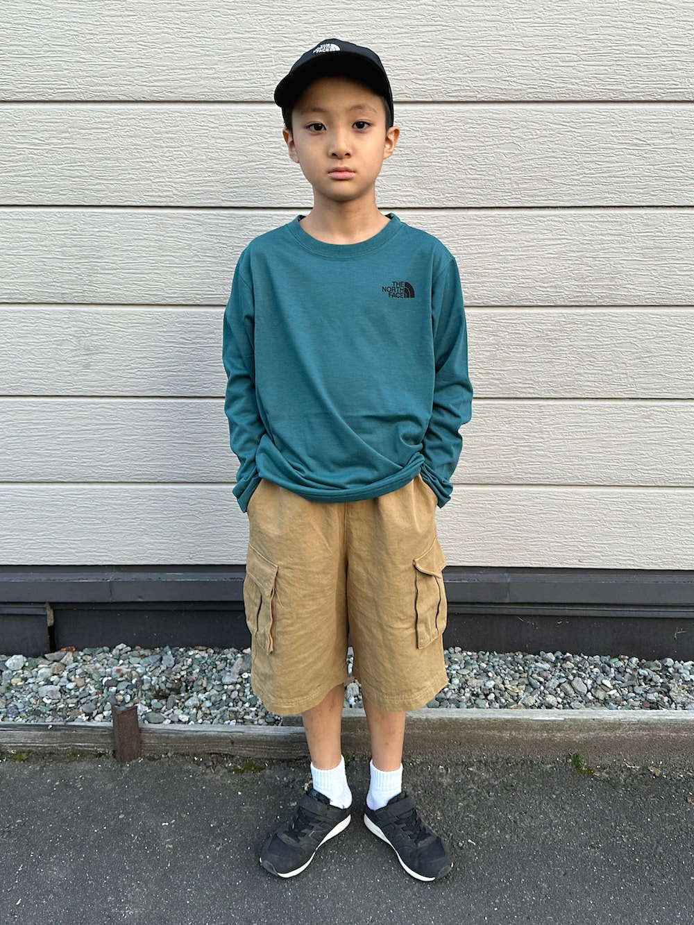 グリーン系のTシャツ/カットソー、ベージュ系のその他パンツ、ブラック系のスニーカーを着用したキッズの秋コーディネートの3枚目の写真