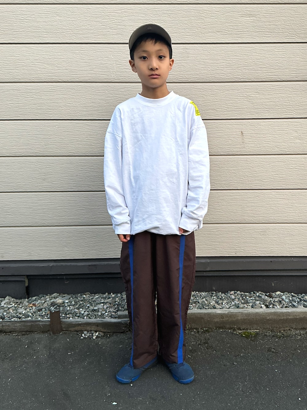 ブルー系のスニーカー、ホワイト系のTシャツ/カットソー、ブラウン系のパンツを着用したキッズの秋コーディネートの4枚目の写真