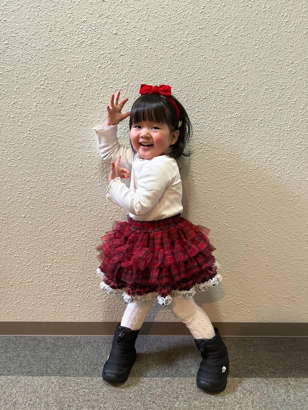 ホワイト系のTシャツ/カットソー、レッド系のその他パンツ、ブラック系のブーツを着用したキッズの冬コーディネートの5枚目の写真