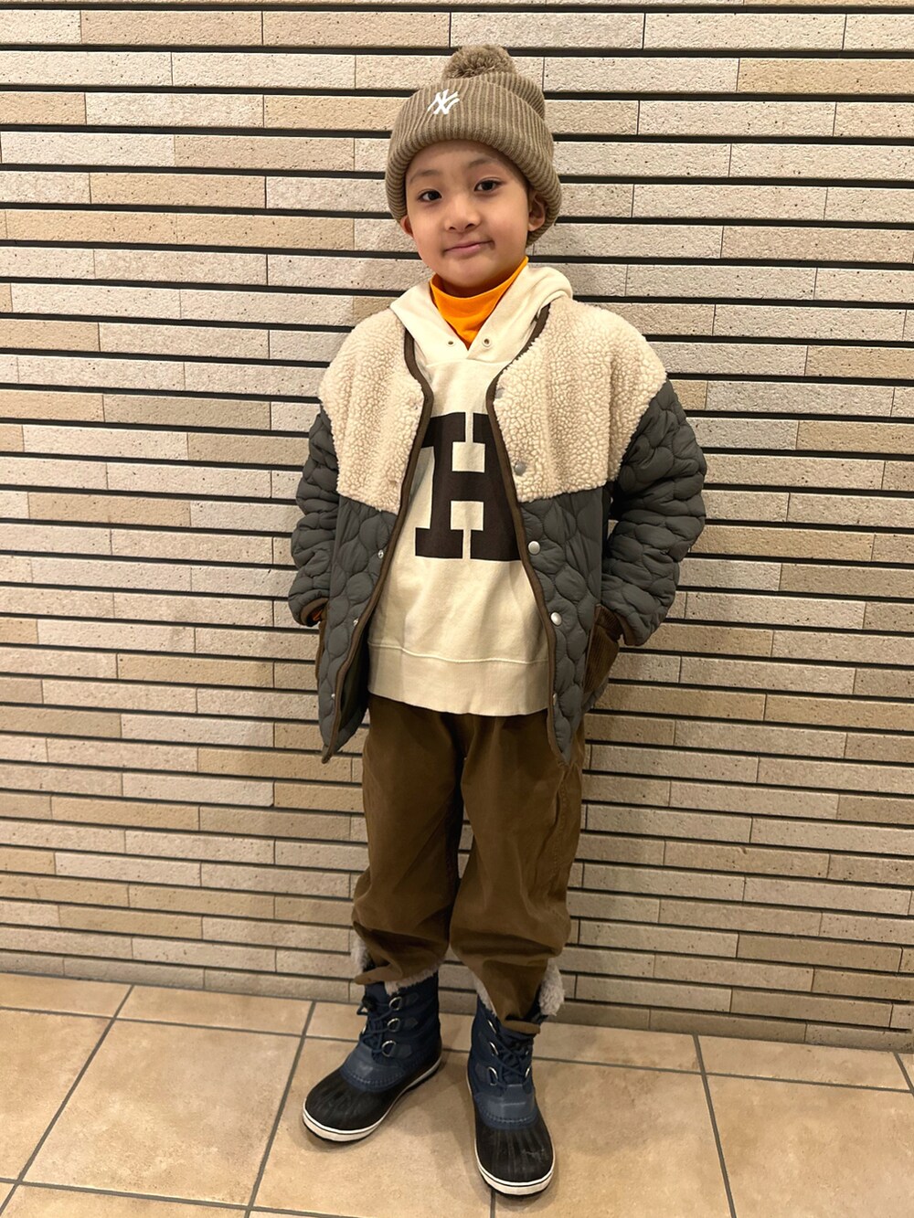 グリーン系のダウンジャケット/コート、ホワイト系のTシャツ/カットソー、オレンジ系のTシャツ/カットソーを着用したキッズの冬コーディネートの2枚目の写真