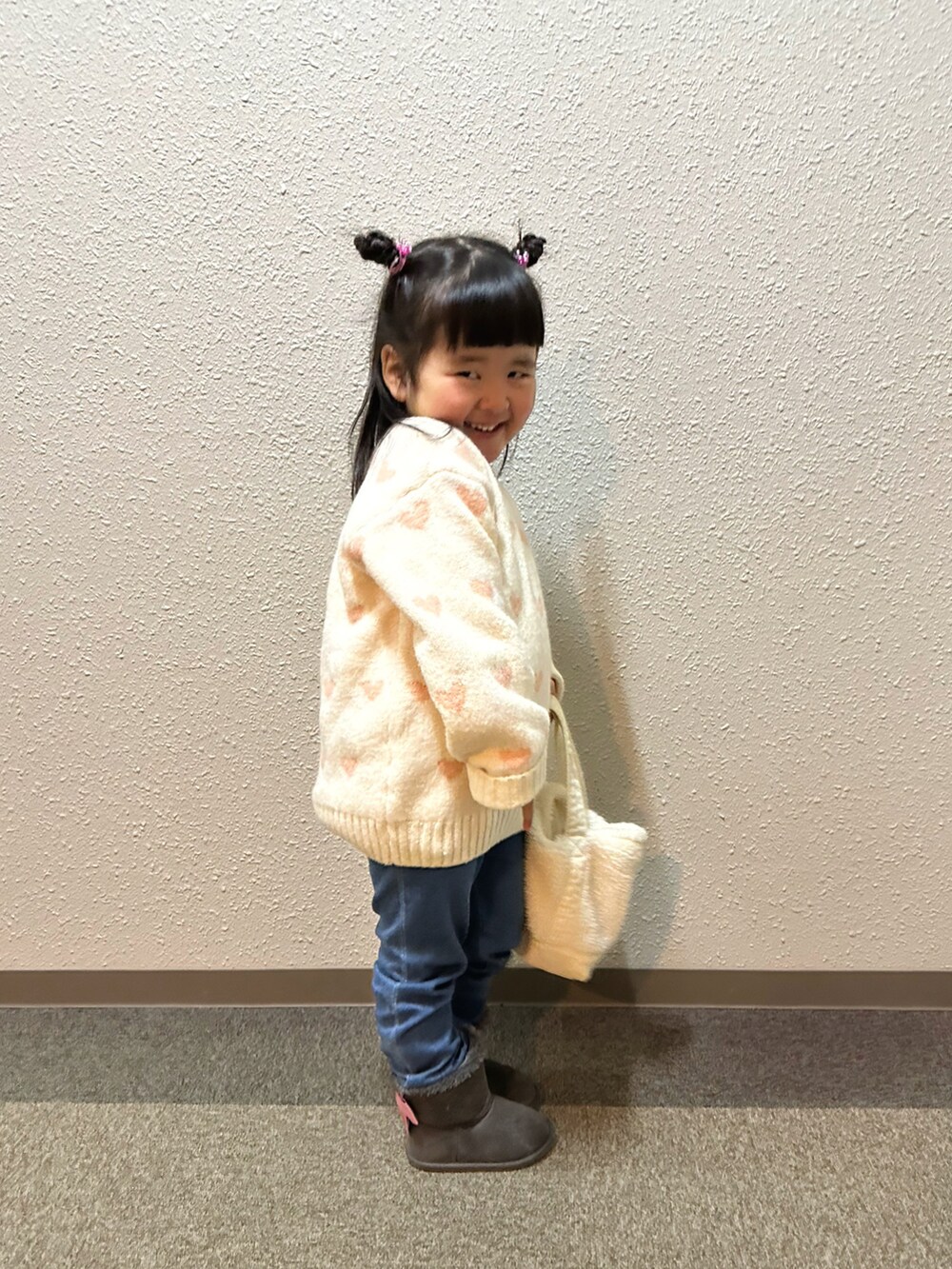 ホワイト系のニット/セーター、ホワイト系のトートバッグ、ブルー系のレギンス/スパッツを着用したキッズの冬コーディネートの2枚目の写真