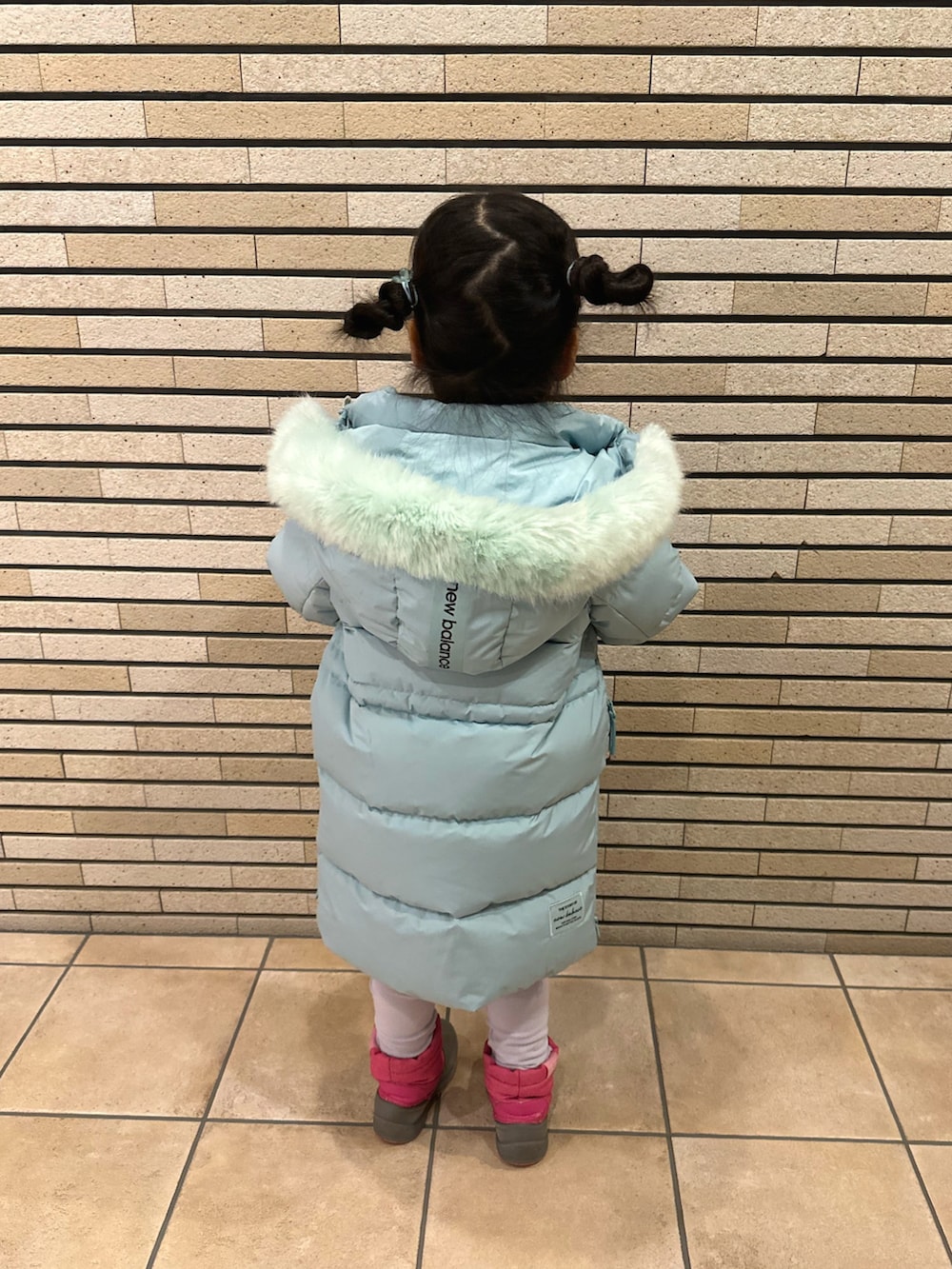 ピンク系のトップス、グリーン系のダウンジャケット/コートを着用したキッズの春コーディネートの2枚目の写真