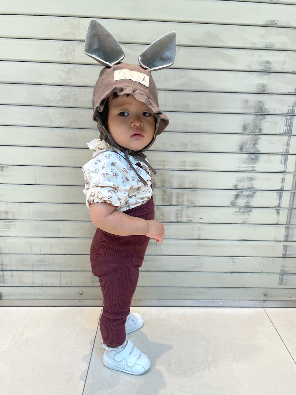 ホワイト系のTシャツ/カットソー、ホワイト系のスニーカー、ブラウン系の帽子を着用したキッズの秋コーディネートの3枚目の写真