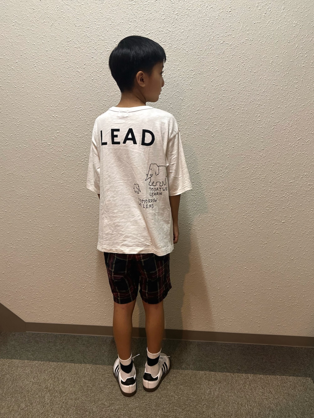 ホワイト系のスニーカー、ホワイト系のTシャツ/カットソー、ブラック系のパンツを着用したキッズの秋コーディネートの2枚目の写真