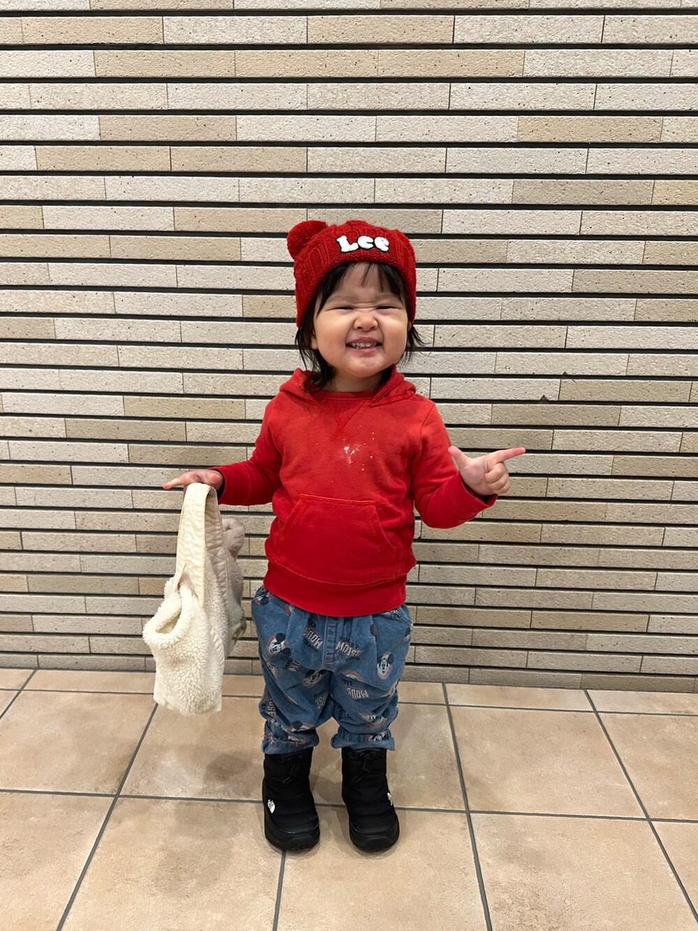 ブラック系のパーカー、ブルー系のデニムパンツ、ブラック系のブーツを着用したキッズの冬コーディネートの5枚目の写真