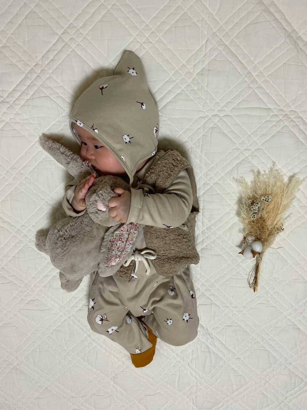 ベージュ系のベスト、ベージュ系のロンパース、ベージュ系のニットキャップ/ビーニーを着用したキッズの秋コーディネートの2枚目の写真