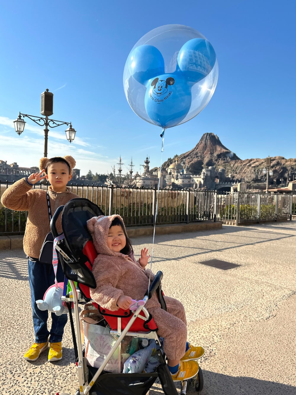 ブラウン系のその他アウター、ブルー系のTシャツ/カットソー、イエロー系のスニーカーを着用したキッズの冬コーディネートの5枚目の写真