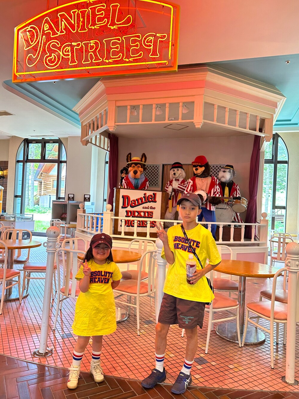 イエロー系のTシャツ/カットソー、イエロー系のワンピース、ブラウン系のパンツを着用したキッズの夏コーディネートの3枚目の写真