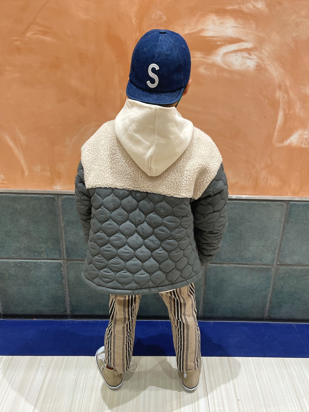 グリーン系のダウンジャケット/コート、ホワイト系のTシャツ/カットソー、ベージュ系のパンツを着用したキッズの冬コーディネートの3枚目の写真