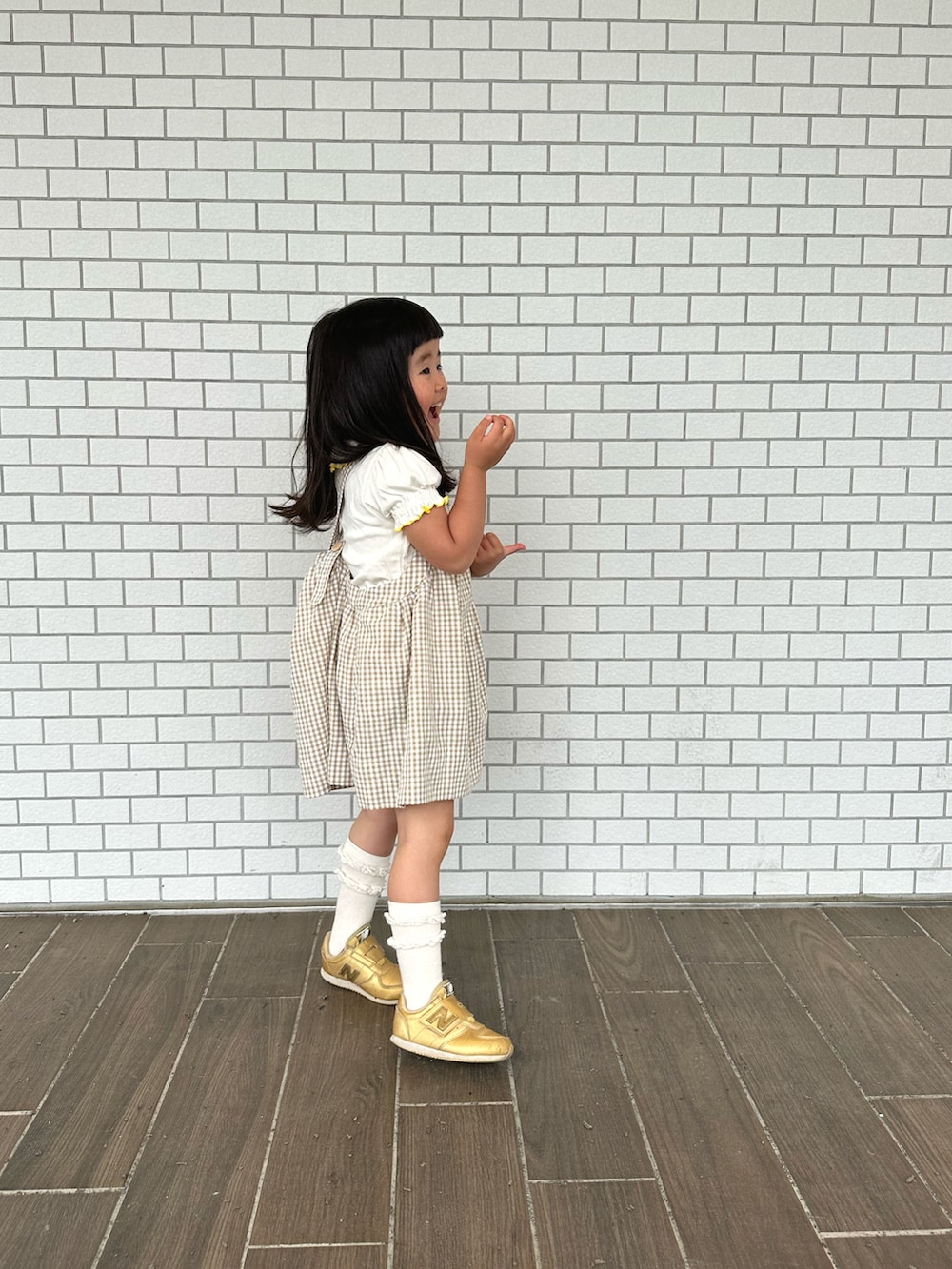 ベージュ系のその他アウター、ゴールド系のスニーカー、ホワイト系のTシャツ/カットソーを着用したキッズの夏コーディネートの3枚目の写真