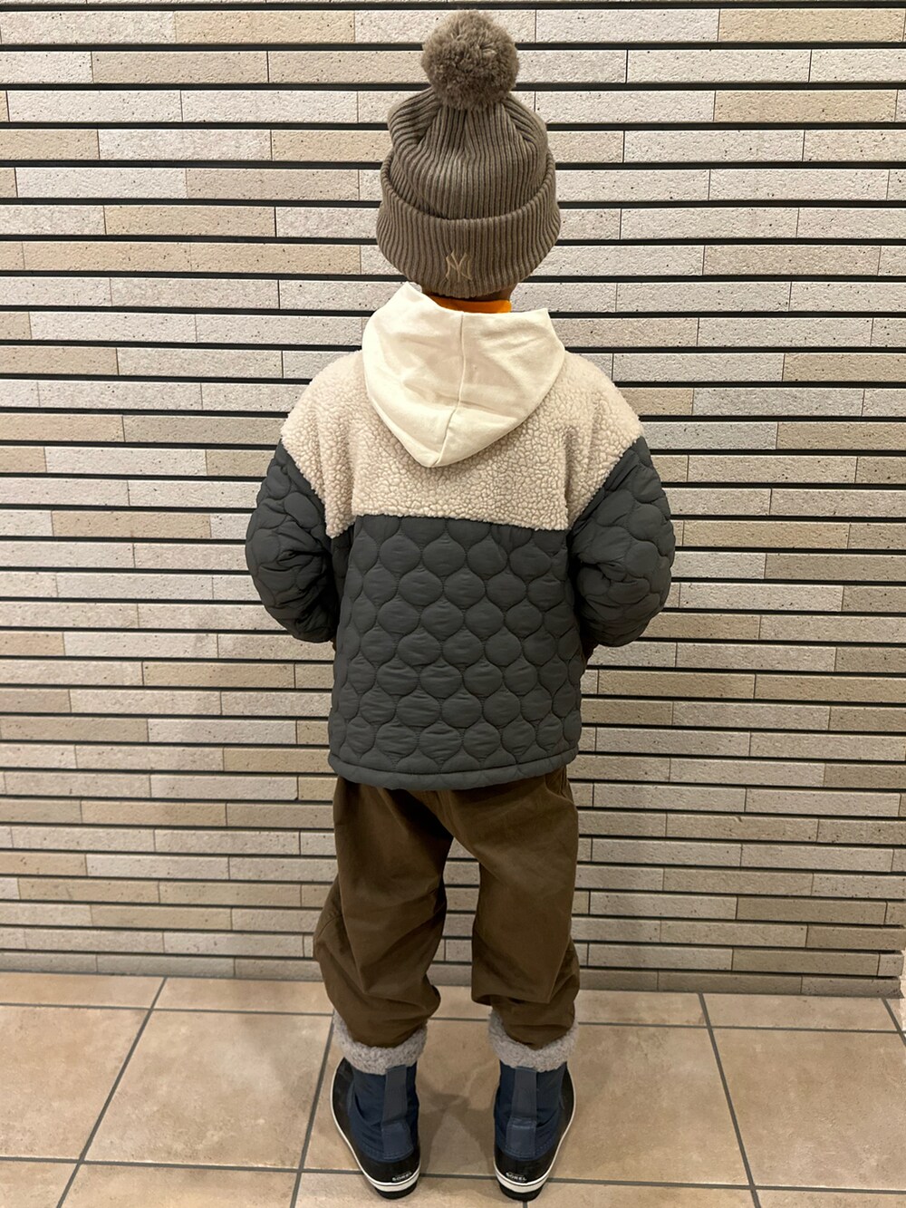 グリーン系のダウンジャケット/コート、ホワイト系のTシャツ/カットソー、オレンジ系のTシャツ/カットソーを着用したキッズの冬コーディネートの4枚目の写真