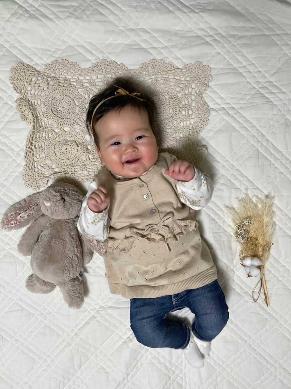 ホワイト系のTシャツ/カットソー、ベージュ系のニット/セーター、ブルー系のデニムパンツを着用したキッズの冬コーディネートの2枚目の写真