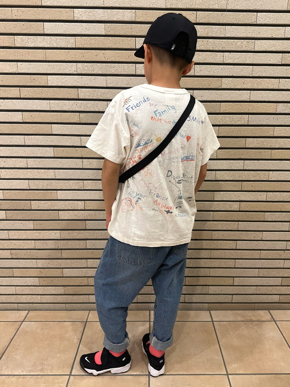 ホワイト系のTシャツ/カットソー、ブルー系のデニムパンツ、ブラック系のスニーカーを着用したキッズの春コーディネートの2枚目の写真