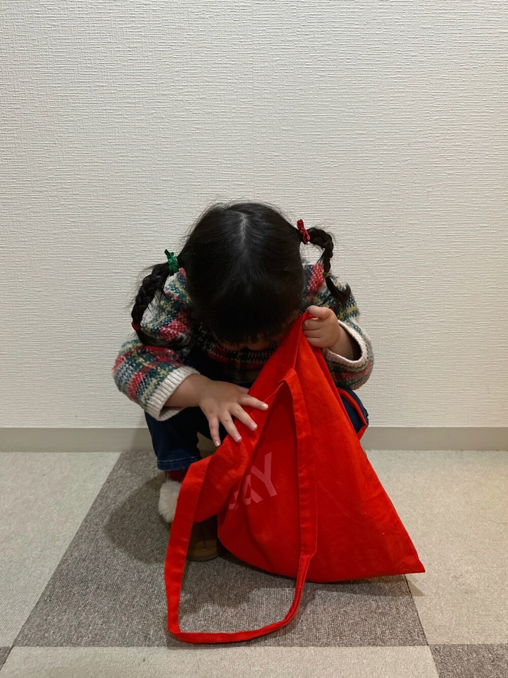 レッド系のニット/セーター、ブルー系のその他パンツ、イエロー系のブーツを着用したキッズの冬コーディネートの3枚目の写真