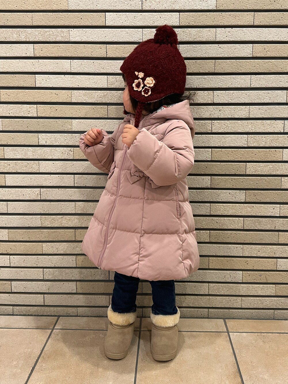 ピンク系のダウンジャケット/コート、ブルー系のその他パンツ、ベージュ系のブーツを着用したキッズの冬コーディネートの4枚目の写真