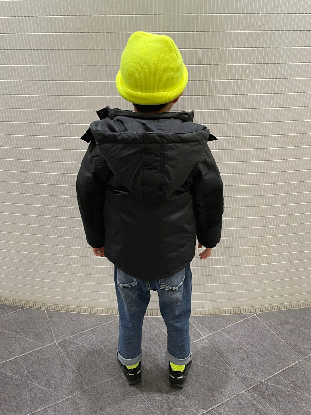 ブラック系のパーカー、ブラック系のダウンジャケット/コート、ブルー系のデニムパンツを着用したキッズの冬コーディネートの2枚目の写真