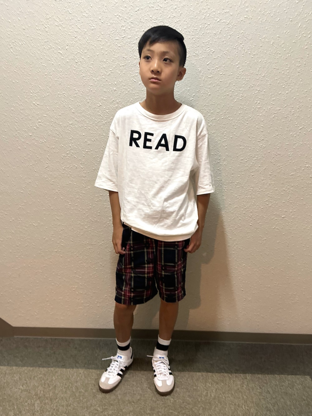 ホワイト系のスニーカー、ホワイト系のTシャツ/カットソー、ブラック系のパンツを着用したキッズの秋コーディネートの3枚目の写真