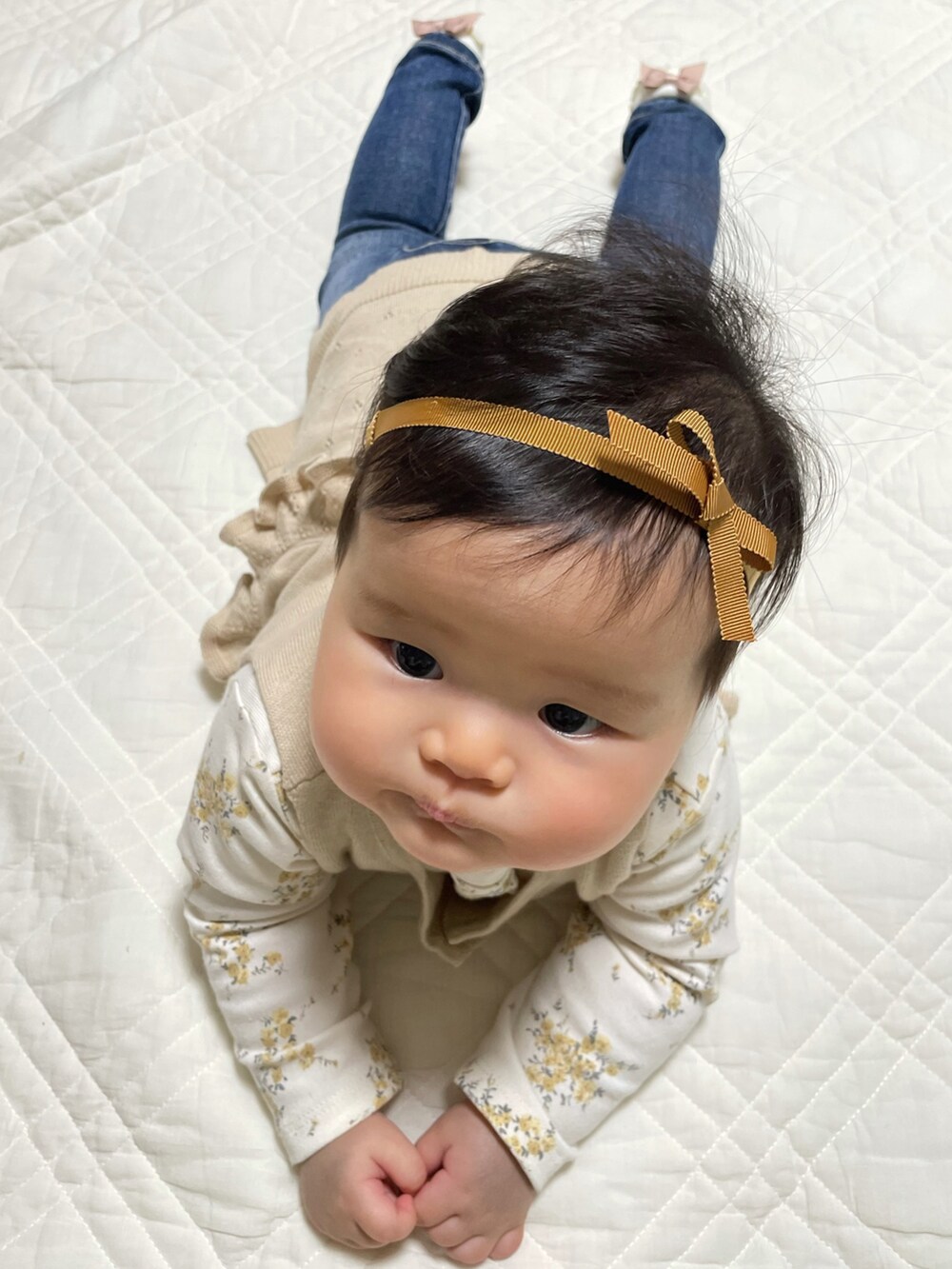 ホワイト系のTシャツ/カットソー、ベージュ系のニット/セーター、ブルー系のデニムパンツを着用したキッズの冬コーディネートの4枚目の写真