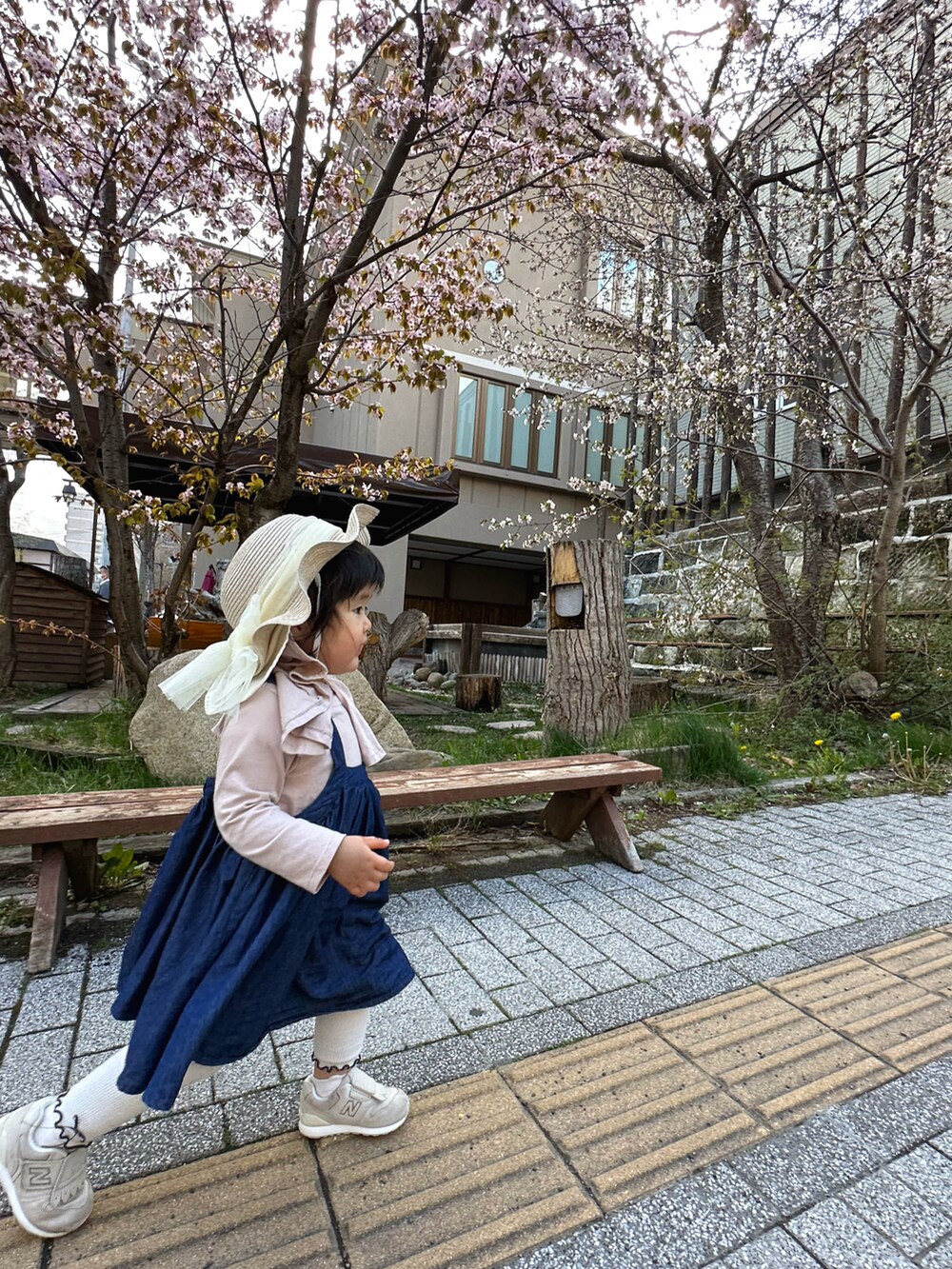 ピンク系のTシャツ/カットソー、ブルー系のワンピース、ホワイト系のスニーカーを着用したキッズの春コーディネートの4枚目の写真