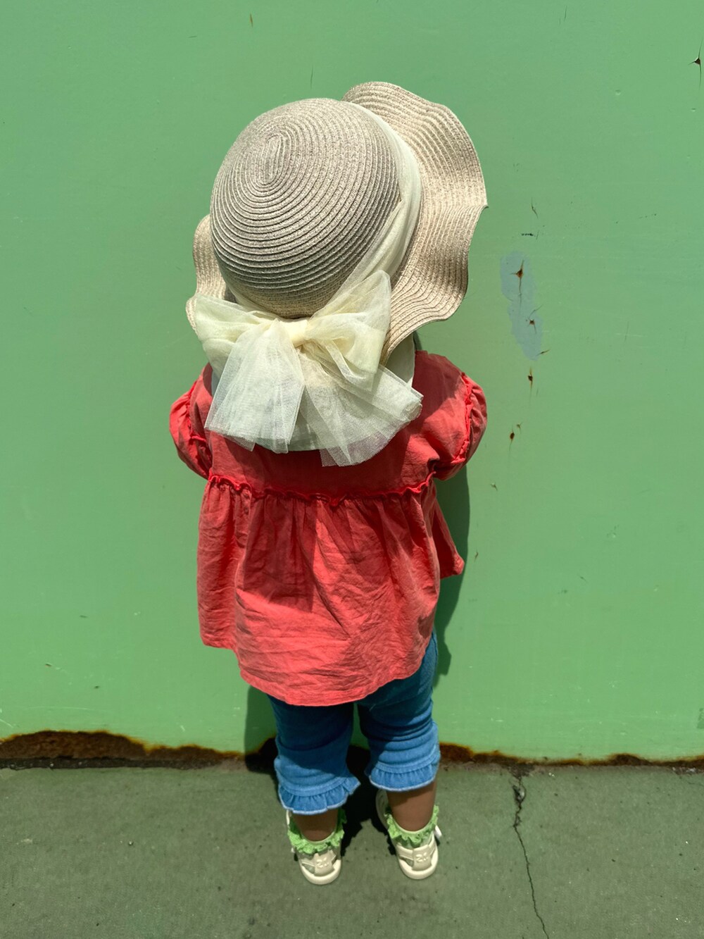 ピンク系のシャツ/ブラウス、ホワイト系のサンダル、ベージュ系のハットを着用したキッズの春コーディネートの3枚目の写真