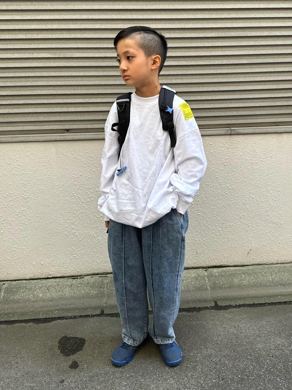 ホワイト系のTシャツ/カットソー、ブルー系のデニムパンツ、ブラック系のバックパック/リュックを着用したキッズの秋コーディネートの2枚目の写真