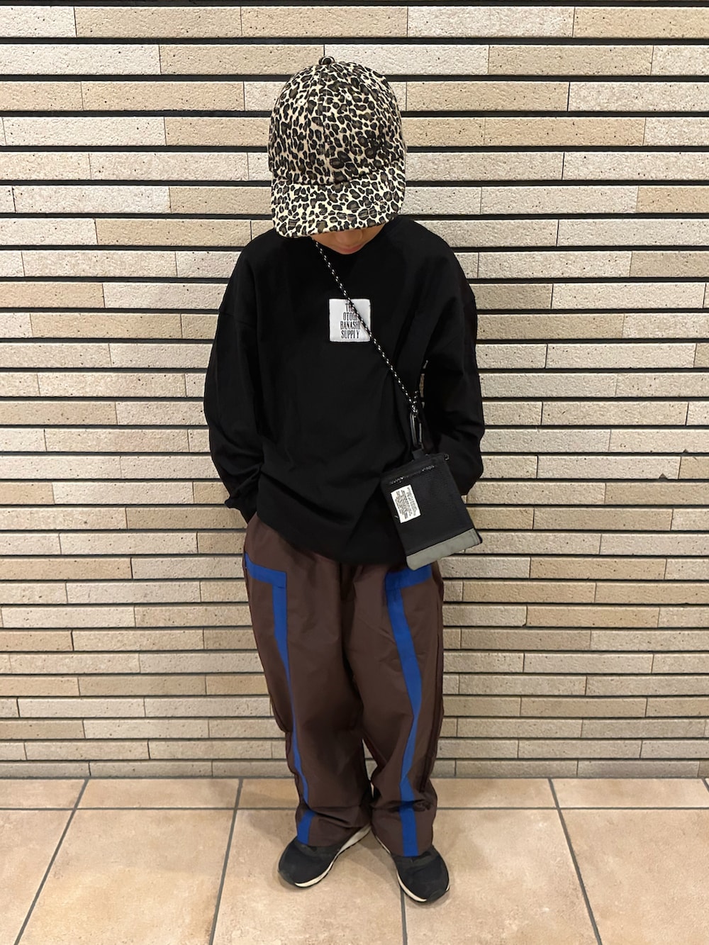 ブラック系のTシャツ/カットソー、ブラウン系のパンツ、ブラック系のスニーカーを着用したキッズの秋コーディネートの4枚目の写真