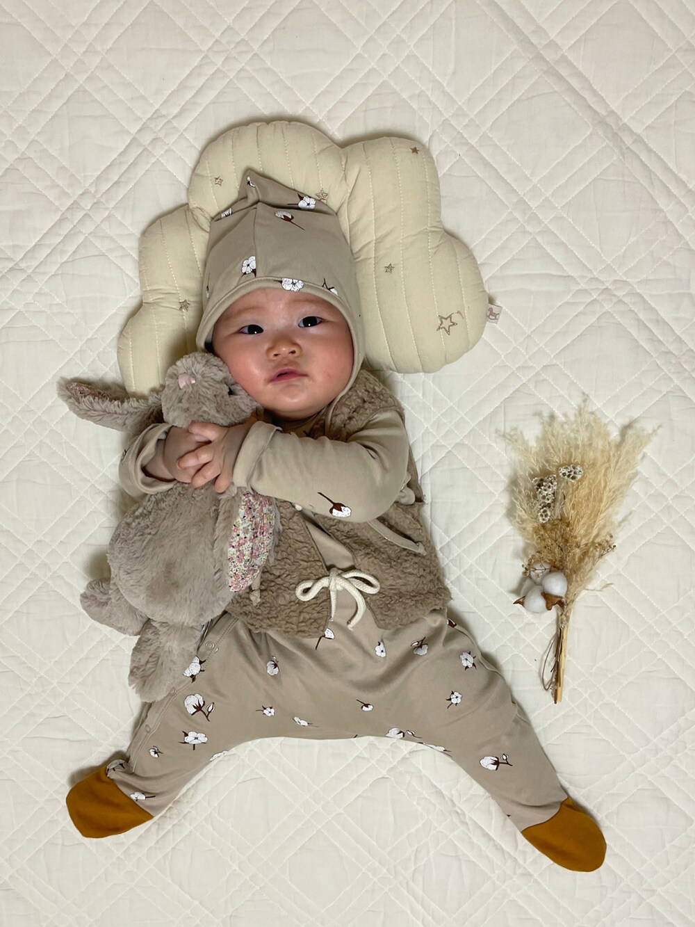 ベージュ系のベスト、ベージュ系のロンパース、ベージュ系のニットキャップ/ビーニーを着用したキッズの秋コーディネートの4枚目の写真