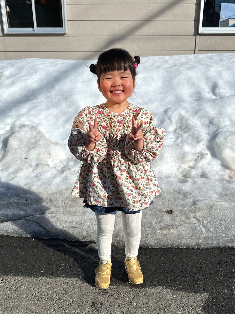 ピンク系のチュニック、ブルー系のデニムパンツ、ゴールド系のスニーカーを着用したキッズの春コーディネートの5枚目の写真