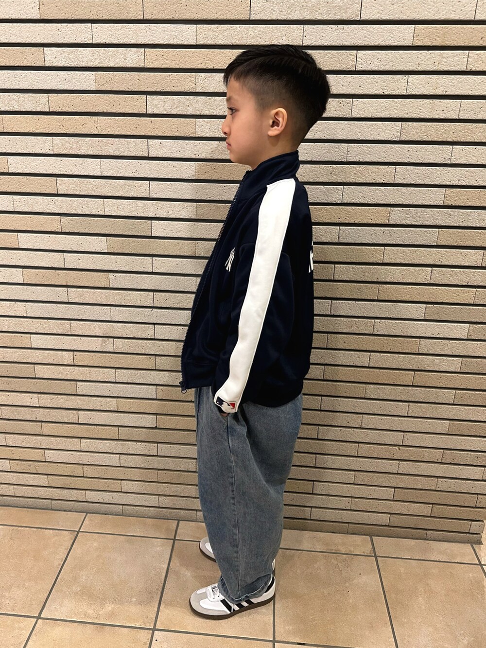 ブルー系のジャージ、ホワイト系のTシャツ/カットソー、ブルー系のデニムパンツを着用したキッズの春コーディネートの2枚目の写真