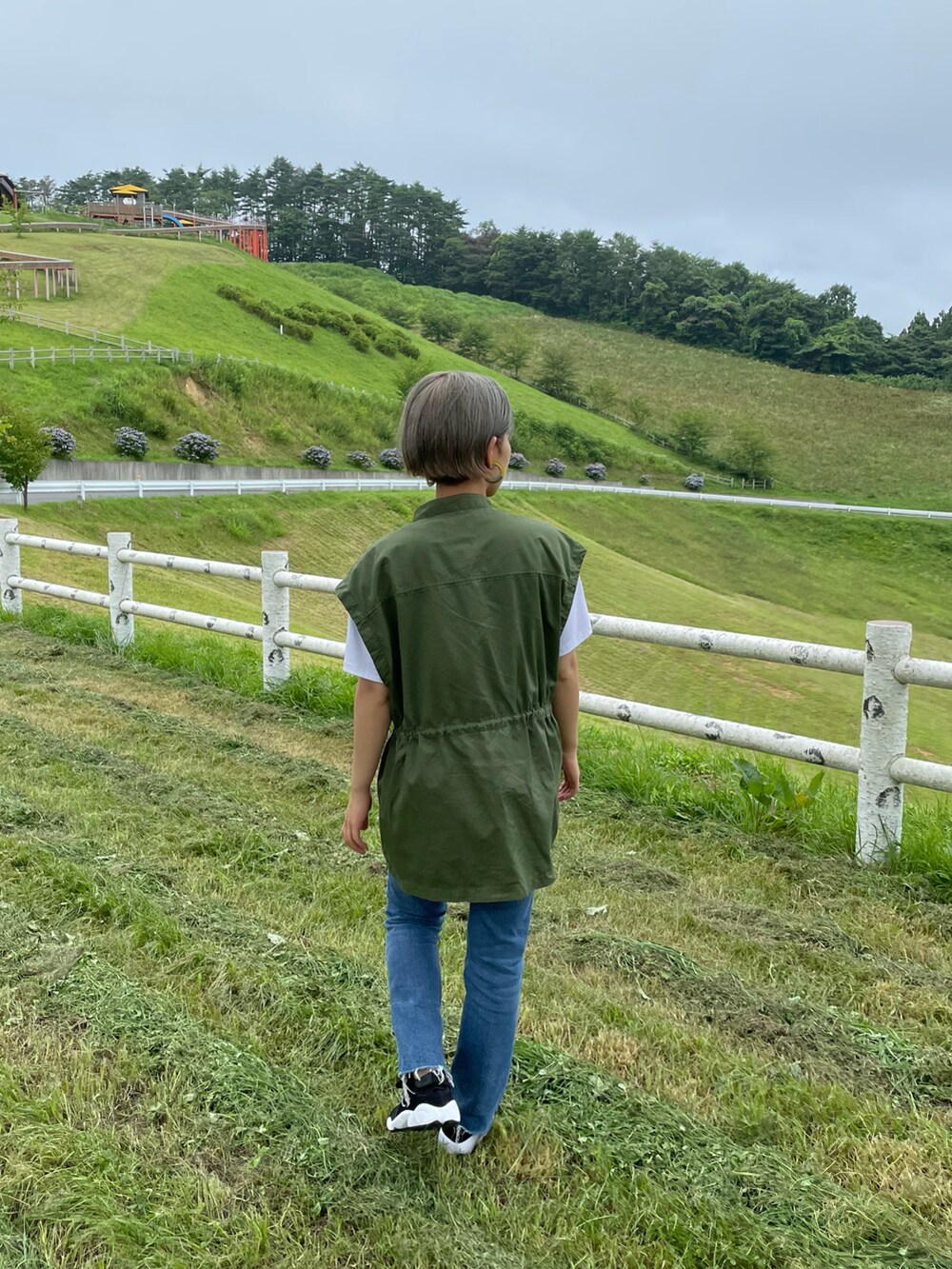 グリーン系のシャツ/ブラウス、ブルー系のデニムパンツを着用したレディースの秋コーディネートの2枚目の写真