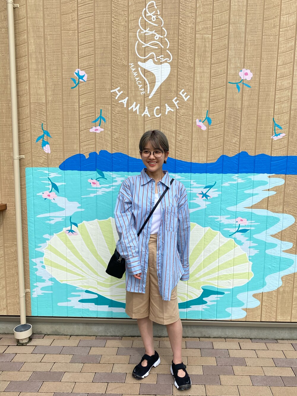 ブルー系のシャツ/ブラウス、ホワイト系のタンクトップ、ベージュ系のチノパンツを着用したレディースの秋コーディネートの3枚目の写真