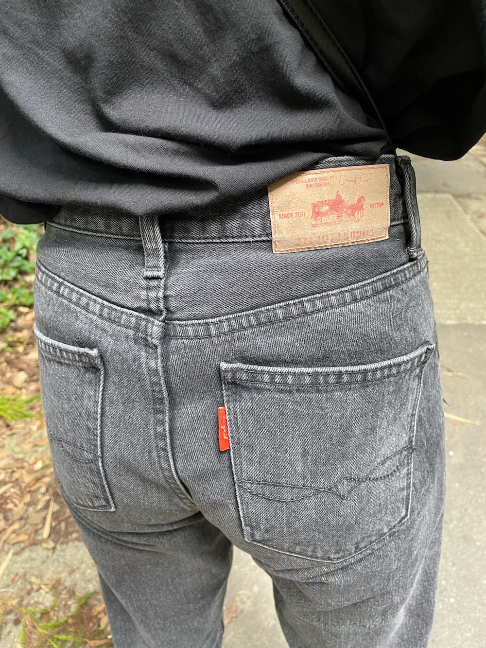 ブラック系のデニムパンツ、ブラック系のTシャツ/カットソーを着用したレディースの秋コーディネートの3枚目の写真