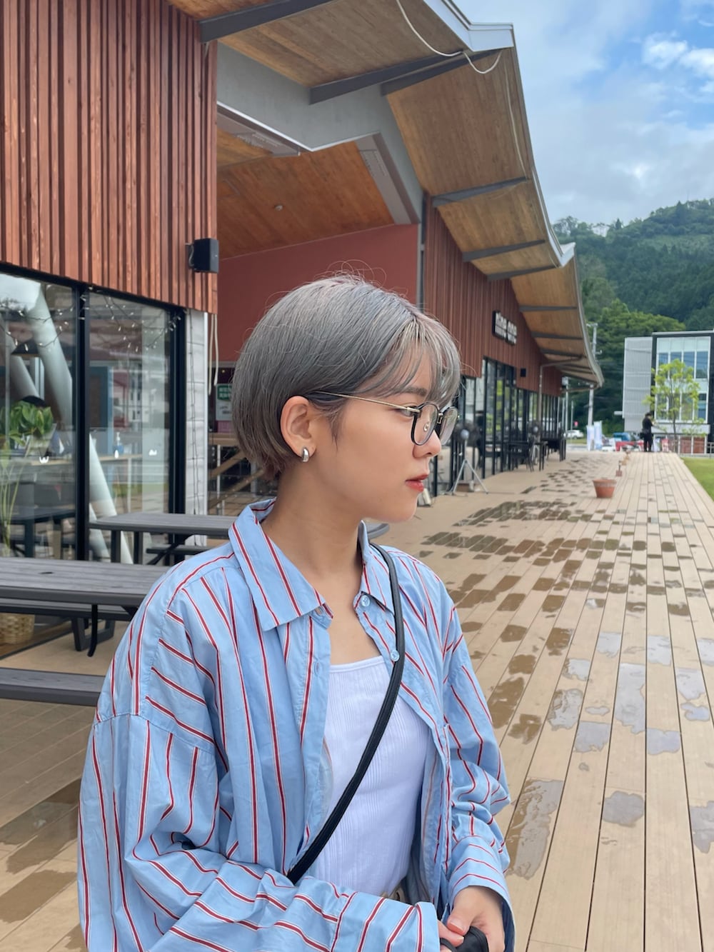 ブルー系のシャツ/ブラウス、ホワイト系のタンクトップ、ベージュ系のチノパンツを着用したレディースの秋コーディネートの2枚目の写真