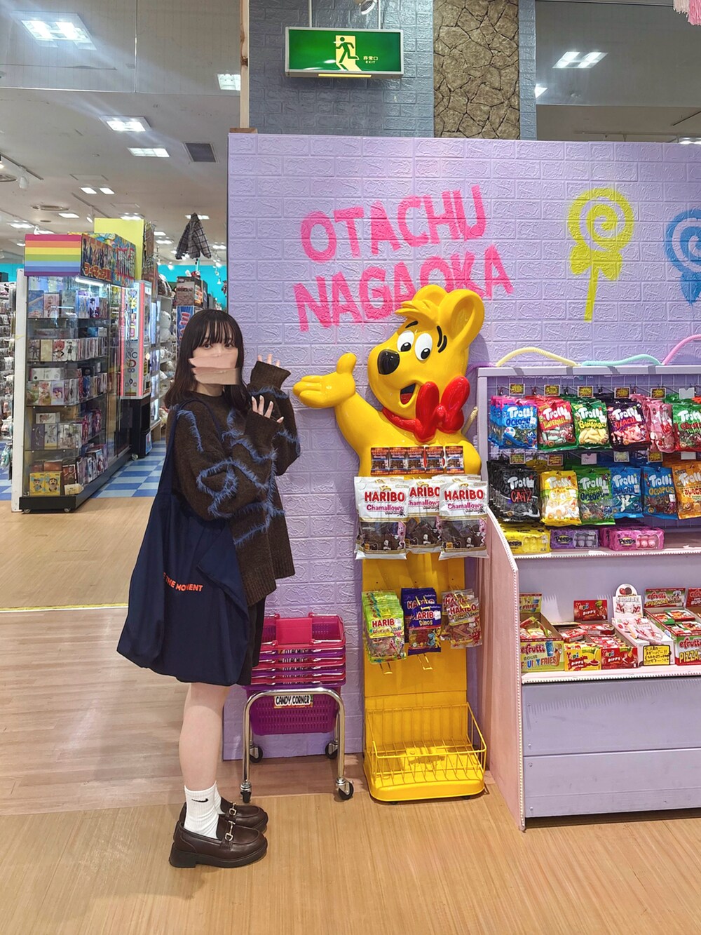 ブラウン系のニット/セーター、ブラウン系のローファー、ブルー系のトートバッグを着用したレディースの秋コーディネートの2枚目の写真