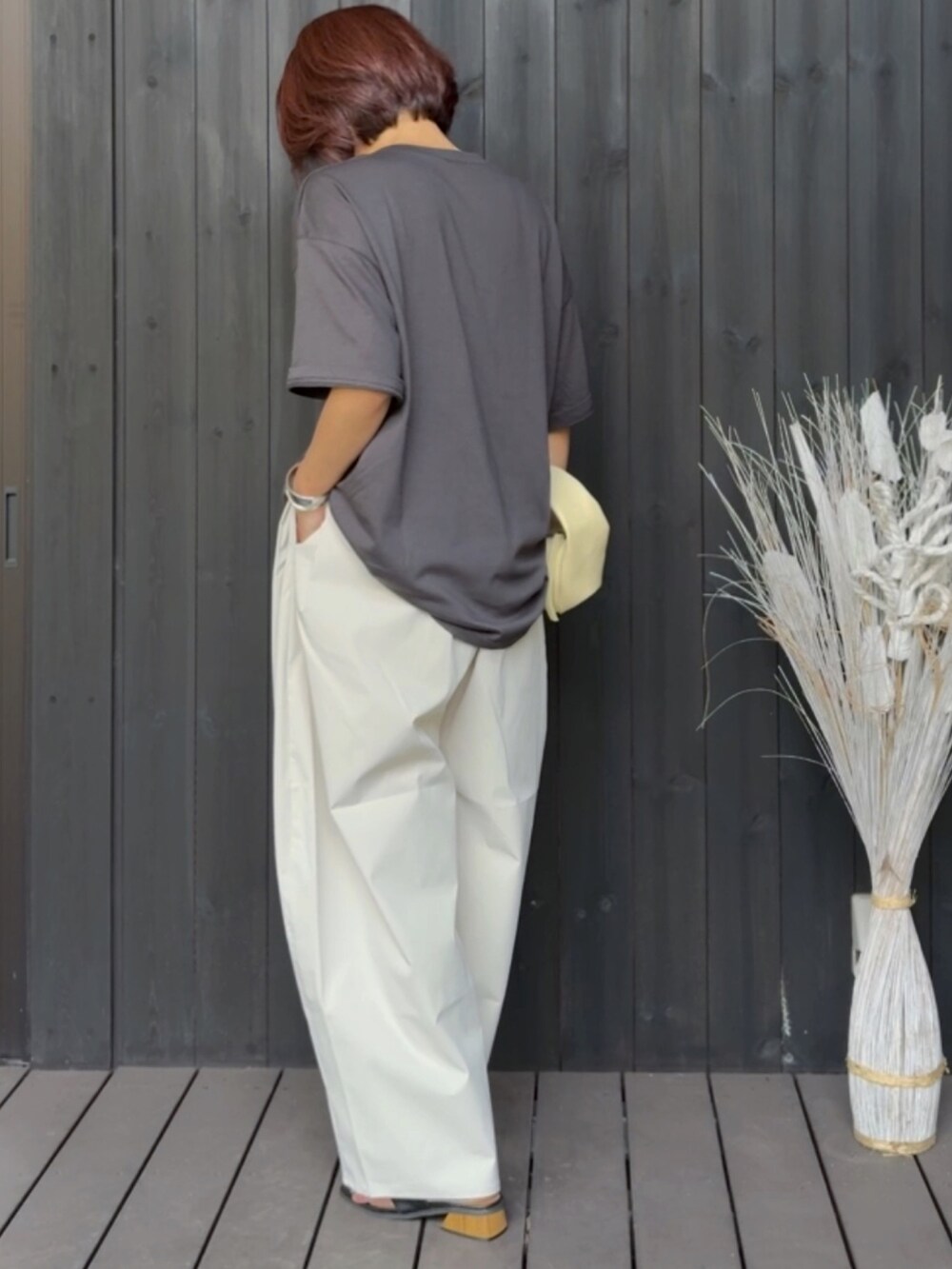 ブラック系のサンダル、グレー系のTシャツ/カットソー、ホワイト系のチノパンツを着用したレディースの夏コーディネートの2枚目の写真