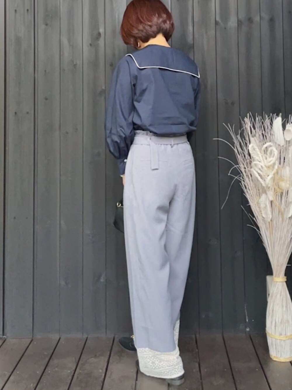 ブルー系のシャツ/ブラウス、グレー系のその他パンツ、ブラック系のハンドバッグを着用したレディースの春コーディネートの3枚目の写真