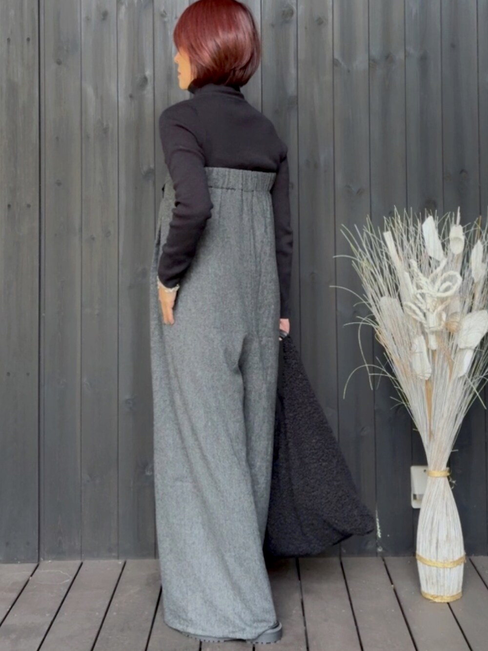 グレー系のサロペット/オーバーオール、ブラック系のニット/セーター、ブラック系のトートバッグを着用したレディースの冬コーディネートの2枚目の写真