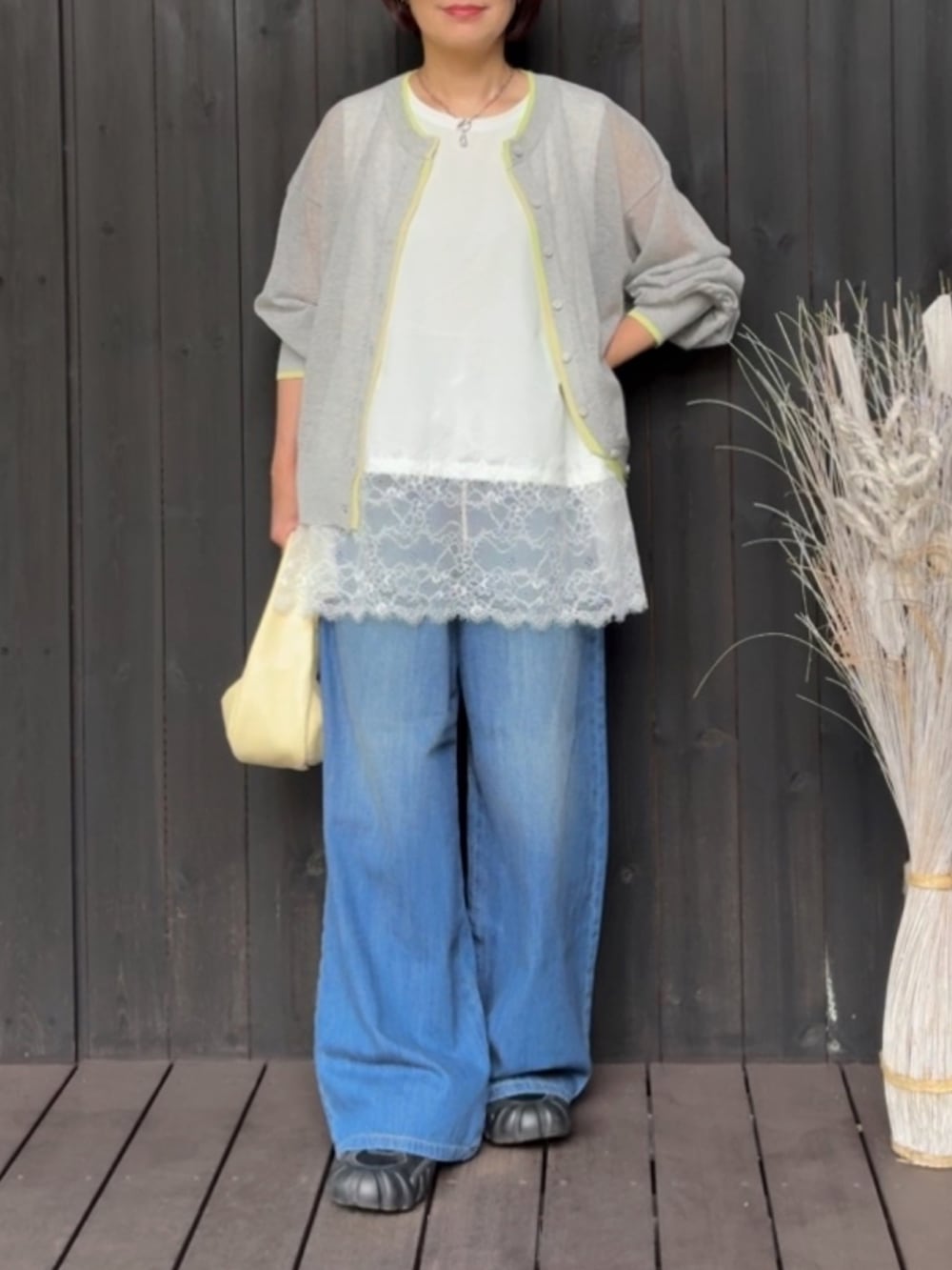 ホワイト系のTシャツ/カットソー、グレー系のカーディガン/ボレロ、ブルー系のデニムパンツを着用したレディースの春コーディネートの2枚目の写真