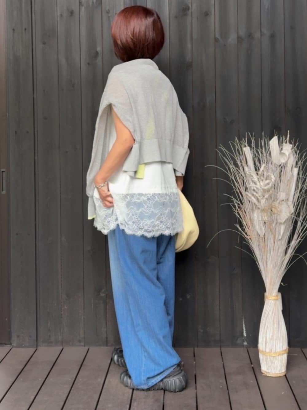 ホワイト系のTシャツ/カットソー、グレー系のカーディガン/ボレロ、ブルー系のデニムパンツを着用したレディースの春コーディネートの3枚目の写真