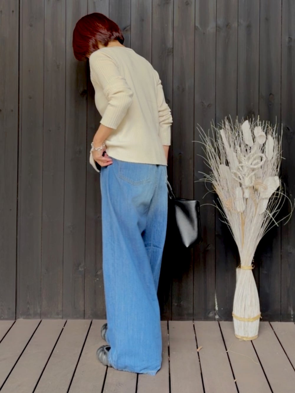 ホワイト系のカーディガン/ボレロ、ブルー系のデニムパンツ、ブラック系のスニーカーを着用したレディースの春コーディネートの2枚目の写真