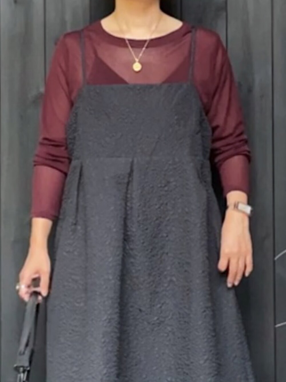 ブラウン系のTシャツ/カットソー、ブラック系のワンピース、ブラック系のショルダーバッグを着用したレディースの秋コーディネートの4枚目の写真